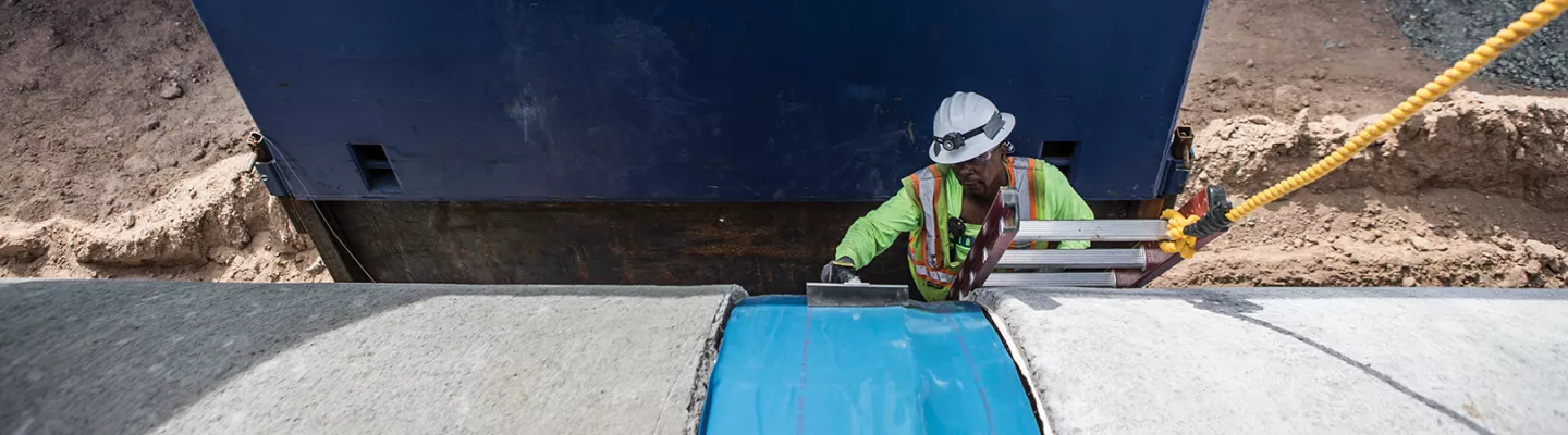 Worker in a trench wearing PPE