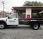 White Ford single-axle dump truck parked outside outside of a garage