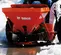 Red Bobcat Spreader Attachment on a skid steer in the snow