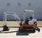 White, red and gray TAKEUCHI 4,000-5,000 lb. Mini Excavator, Zero Tail Swing