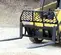 yellow skid steer using a fork attachment on a jobsite